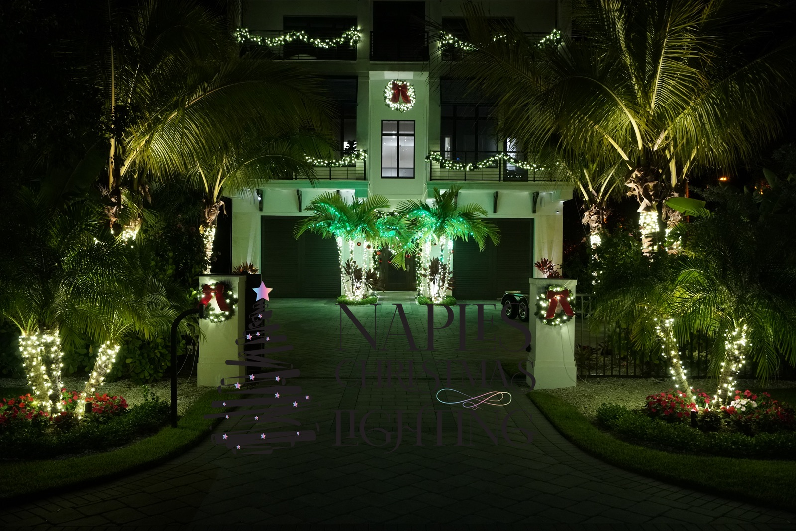 Coastal Naples estate driveway lined with lit palms and Christmas wreaths